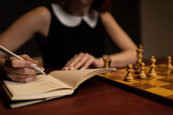 Γυναίκα Που Μελετά Σκακιστικές Κινήσεις Στο Βιβλίο Σκοτεινό Φόντο — Φωτογραφία Αρχείου