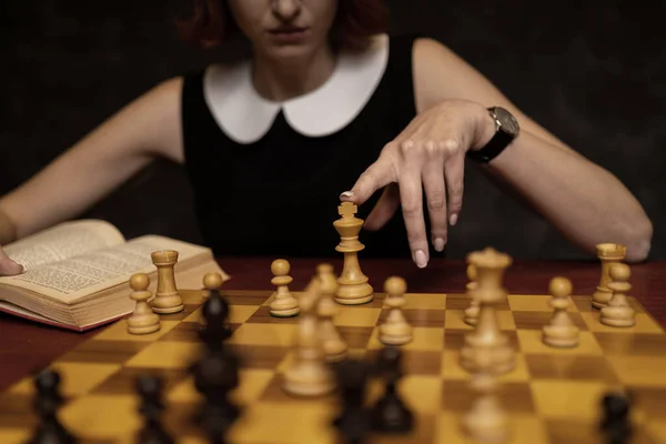Γυναίκα Μελετά Σκάκι Σκούρο Φόντο Δείχνοντας Κομμάτι Του Βασιλιά — Φωτογραφία Αρχείου
