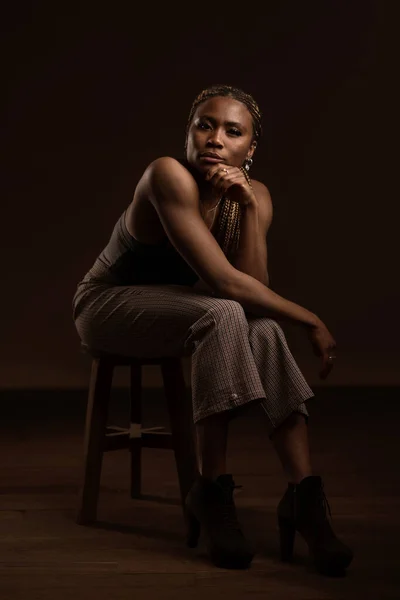 Confident Portrait African Black Woman Sit Wooden Stool Dark Background — Stock Photo, Image