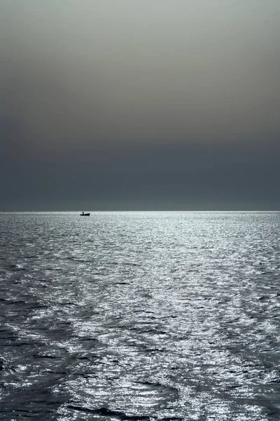 夕阳西下的渔船倒映在水面上 — 图库照片