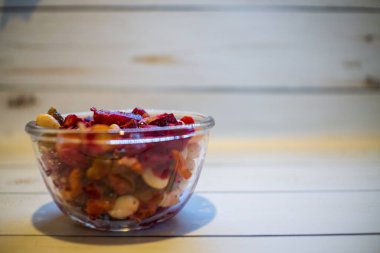 Seasonal salad vinaigrette with beetroot and beans in the glass bowl on the white wooden table. Copy space