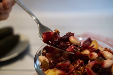 Vinaigrette salad on the fork. 