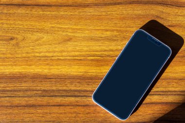 Ahşap masada akıllı telefon. Boşluğu kopyala