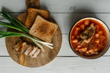 Ev yapımı Ukrayna borsch 'u. Kasede pancar çorbası. Yeşil soğan, ekmek, turşulu domuz pastırması. 