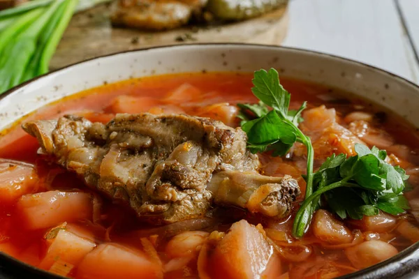 stock image Homemade ukrainian borsch - beetroot soup in a bowl. Green onion, bread, bacon with herbs and pickles 