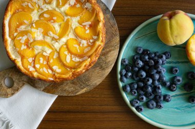 Şeftalili süzme peynirli güveç turtası. Şeftali ve yabanmersinli seramik tabak