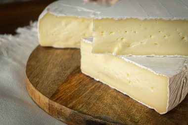 Ahşap zemin üzerinde krem peyniri, fındık, bal ve meyveli peynir. Süt ürünleri.