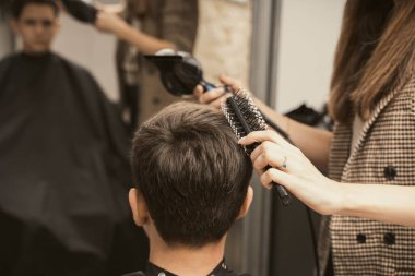 Berber dükkanı adamlarının saç stili. Genç adam modern bir saç kesimi yaptırıyor. Kuaför kuaförü berber dükkanında saç kurutma müşterisi. Erkek modası ve tarzı. Saç bakımı, güzellik endüstrisi, berber konsepti..