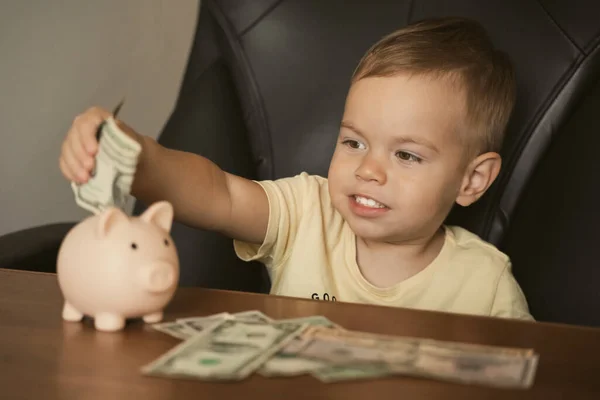聪明快乐的男孩把小钱钞票放进储蓄罐里 在储蓄罐里存钱 学习存钱 保险和人的概念 — 图库照片