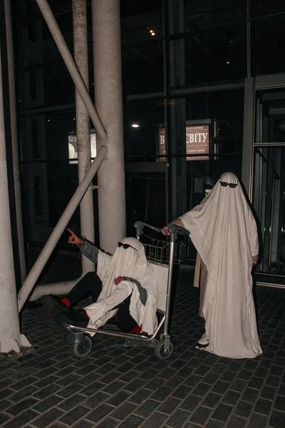 Hayalet arkadaşlar beyaz yatak çarşafları içinde fotoğraf çekiyorlar.