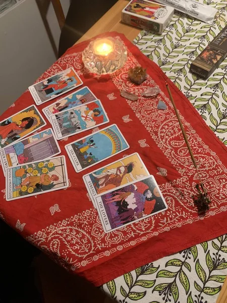 a lot of different tarot cards with magic stones on red clothes