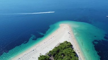 Zlatni Rat (Altın Boynuz veya Altın Pelerin), Hırvatistan 'ın Brac Adası plajında insanların yüzdüğü hava manzarası. Turistler Avrupa 'da yaz seyahatinin tadını çıkarıyorlar. Adriyatik Denizi 'nin berrak mavi suları
