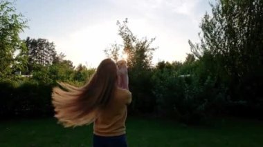 Gün batımında elinde küçük şirin bir Chihuahua köpeği tutan bir kadın. Kahverengi saçlı, uzun saçlı, minyatür bir köpek. Sevimli küçük arkadaş. Arkadaş canlısı köpek. Komik safkan köpek dişi. Yavaş çekim. 