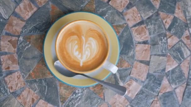 心の形で泡とコーヒーのおいしい香りのカップ 大理石のテーブルの上に立つ — ストック動画