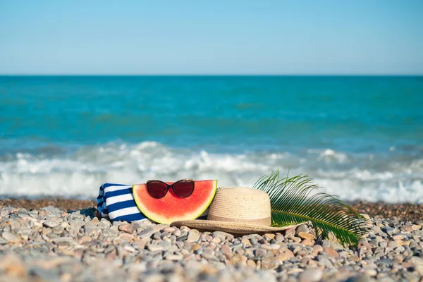 Hat Sunglasses Watermelon Tropical Leaf Towel Laying Stony Beach Blue — Zdjęcie stockowe