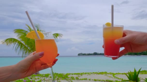 乾杯するカクテルで手を閉じてください ロマンチックなカップルはガラスでクリンクしています カップルは彼女の熱帯の休日を楽しむ 夏の旅行休暇のコンセプト — ストック動画