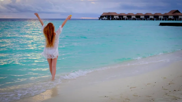 몰디브해질 칵테일마시는 소녀는 행복하게 있습니다 청록색 배경에 있습니다 — 스톡 사진