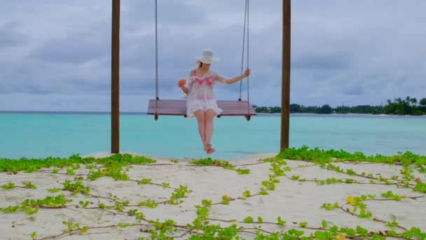 穿着比基尼的女人在摇晃 女性在马尔代夫很快乐 蓝色蓝绿色的海洋为背景 女孩喜欢她的热带假期 暑假的概念 慢动作4K视频 — 图库视频影像
