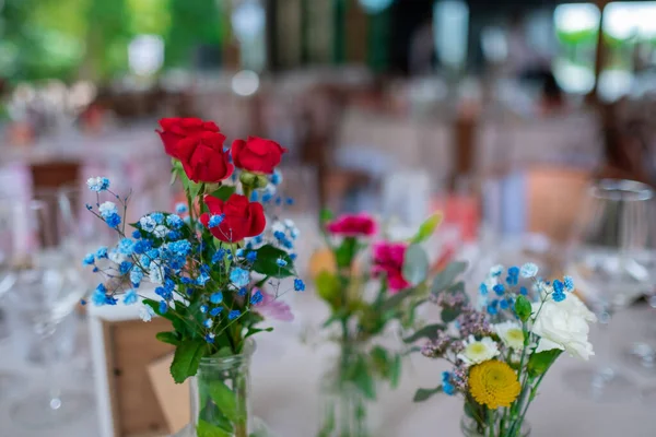Wedding reception photo. Glasses and flowers on tables. Wedding restaurant white interior decor, no people.