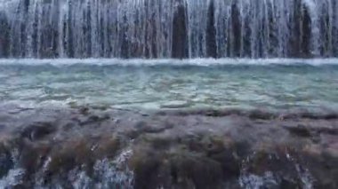 Bir sürü merdiveni olan güzel bir şelale yaptı. Hava aracı görüntüsü. Yatay video. Şelaleyi kapat.