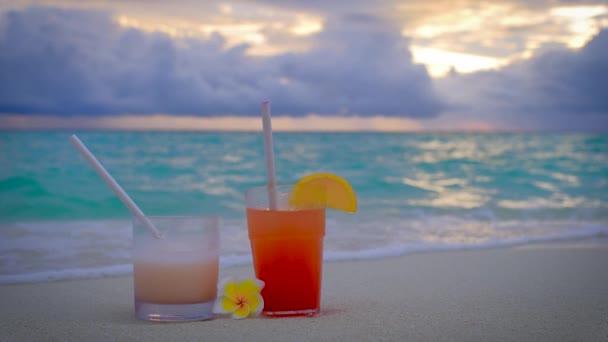 夕阳西下的时候 鸡尾酒喝多了 两杯饮料 蓝色蓝绿色的海洋为背景 暑假的概念 4K慢动作视频 — 图库视频影像