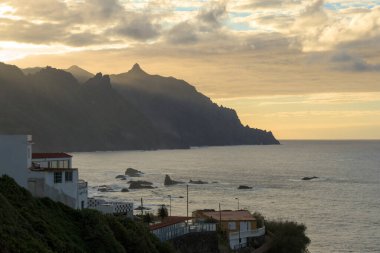 Deniz kenarında güzel bir gün batımı. Güzel bir doğa geçmişi var. Dağlar ve dalgalar. Güzel gökyüzü. 