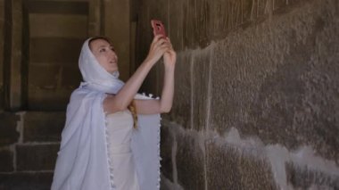 Kadın eski bir Mısır mezarının içinde. Kız hiyerogliflerin fotoğrafını çekiyor. Necropolis, Kahire, Mısır. 