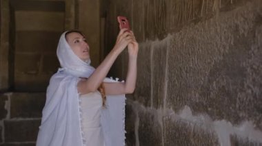 Kadın eski bir Mısır mezarının içinde. Kız hiyerogliflerin fotoğrafını çekiyor. Necropolis, Kahire, Mısır. 