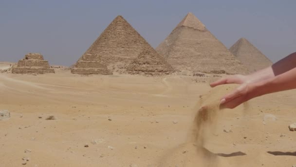 在埃及 女性的手与沙子和吉萨大金字塔在一起 女孩拿着沙子 — 图库视频影像