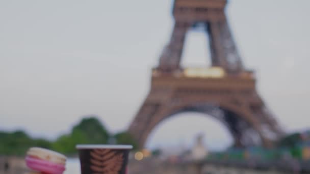 エッフェル塔は フランスのマカロンと明るい背景のコーヒーを提供しています 日没の夕暮れの色の後 スローモーションビデオ — ストック動画