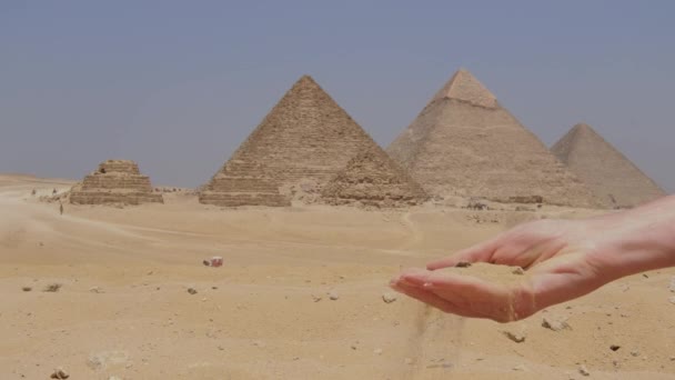 在埃及 女性的手与沙子和吉萨大金字塔在一起 女孩拿着沙子 — 图库视频影像