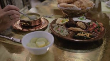 Mısır yemeği masanın üzerindedir. Kaşıklı kadın eli ve mercimek çorbası. Restoranda. Arap mutfağı.