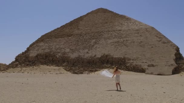 Frau Weißen Kleid Läuft Hintergrund Ist Die Rote Pyramide Sehen — Stockvideo