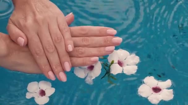 美しい天然ピンクのエレガントなマニキュアと女性の手 大雨だ 美しい女性の爪 水とスキンケアの概念 美容ネイルサロン スローモーション4Kビデオ — ストック動画