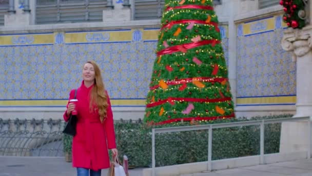 Szczęśliwa Kobieta Czerwonym Płaszczu Torbami Zakupy Filiżanką Kawy Choinka Błyszczącymi — Wideo stockowe