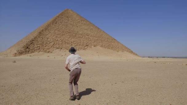 Людина Капелюсі Танцює Стрибає Від Щастя Задньому Плані Червона Піраміда — стокове відео