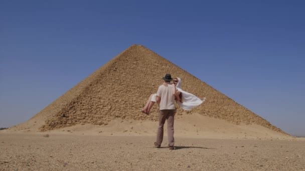 Egy Fehér Ruhás Férfi Egy Nőt Tart Kezében Háttérben Djoser — Stock videók