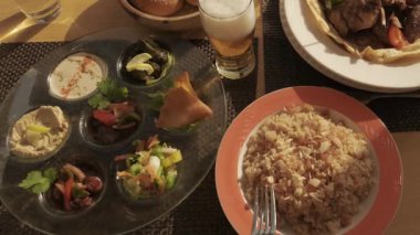 Mısır yemeği masanın üzerindedir. Çatallı ve pirinçli kadın elleri. Arap mutfağına yakın çekim. Bir restoranda tandır roti ekmeği. 