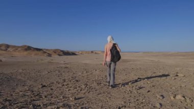 Bu videoda, bir kadın Mısır çölünün uçsuz bucaksız genişliğini keşfediyor, Mısır 'ın büyüleyici manzaraları arasında yürüyüş yolculuğuna çıkarken macera ve seyahat ruhunu somutlaştırıyor..