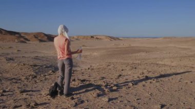 Bu videoda, Mısır 'ın kavurucu çölünün ortasında susuzluğunu gideren bir kadın bu büyüleyici topraklarda yolculuğa çıkarken sıcak hava kavramını vurguluyor..