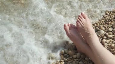 Bu yavaş çekim videosunda ayaklar ve ıslak taşların üzerinde dinlenen ayak izleri var..