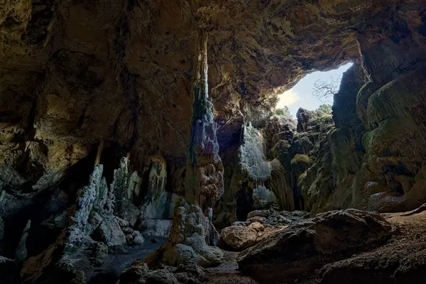 İspanya 'daki doğal bir mağaranın dramatik iç kısımlarında mağara tavanındaki büyük bir delikten içeri sızan doğal ışık tarafından aydınlatılmış çarpıcı dikitler ve sarkıtlar var. Yeraltı manzarası.
