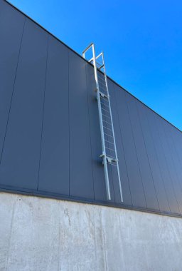 Endüstriyel bir binanın ön cephesindeki teknik merdiven. Yangın çıkışı. Binanın ön cephesi