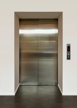 Modern bir yolcu asansörünün parlak metal kapıları. Ön görünüm.
