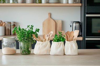 Cam kavanozlar, bambu kaplar, yeniden kullanılabilir pamuk torbaları, ahşap raflar ve saksı bitkileri gibi çevre dostu aksesuarların yer aldığı şık bir sıfır atık mutfağı.. 