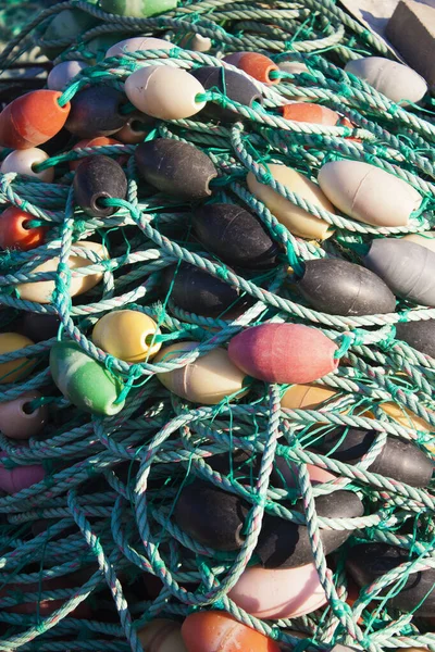 漁港のウォーターフロントにある杭の上に漁網からのブイを持つナイロンロープ — ストック写真