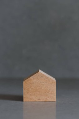 Gri arka planda minyatür evler. Tepede yer alan emlak kavramı