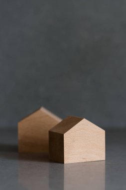 Gri arka planda minyatür evler. Tepede yer alan emlak kavramı