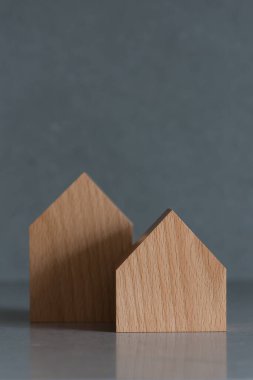 Gri arka planda minyatür evler. Tepede yer alan emlak kavramı