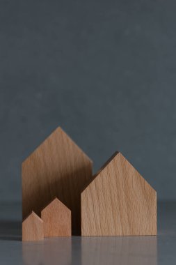 Gri arka planda minyatür evler. Tepede yer alan emlak kavramı